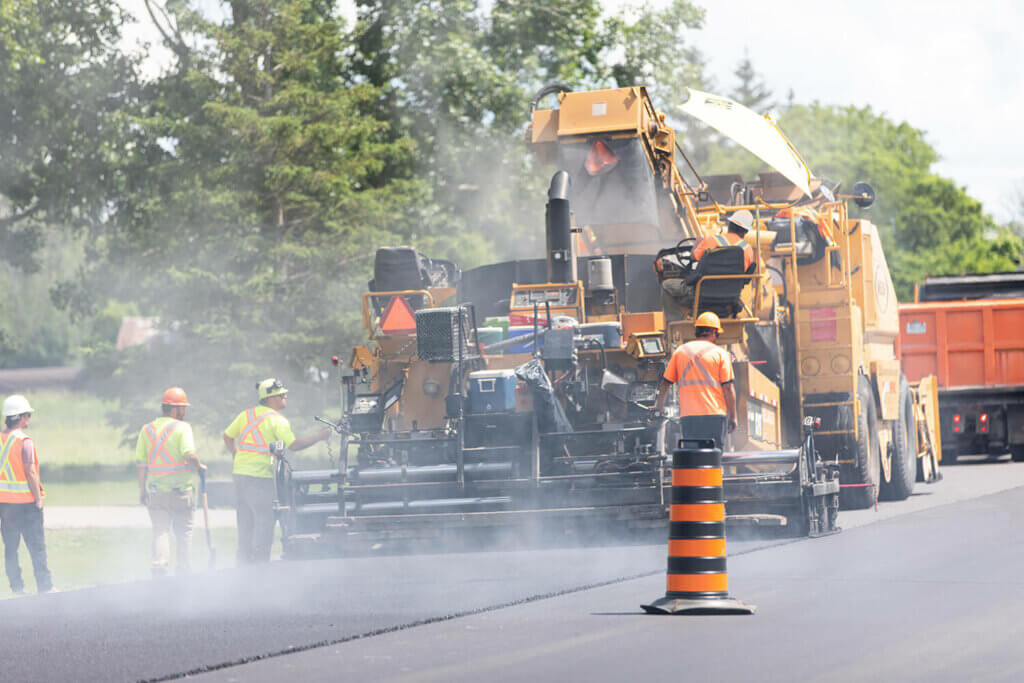 Al Blair workers working on a new road by putting fresh new asphalt on the road